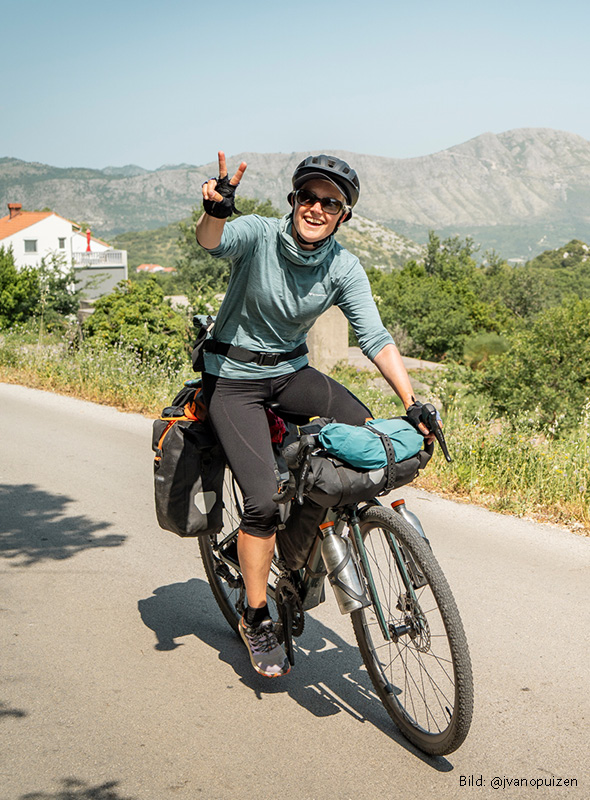 Anni auf Gravelbike macht Peacezeichen